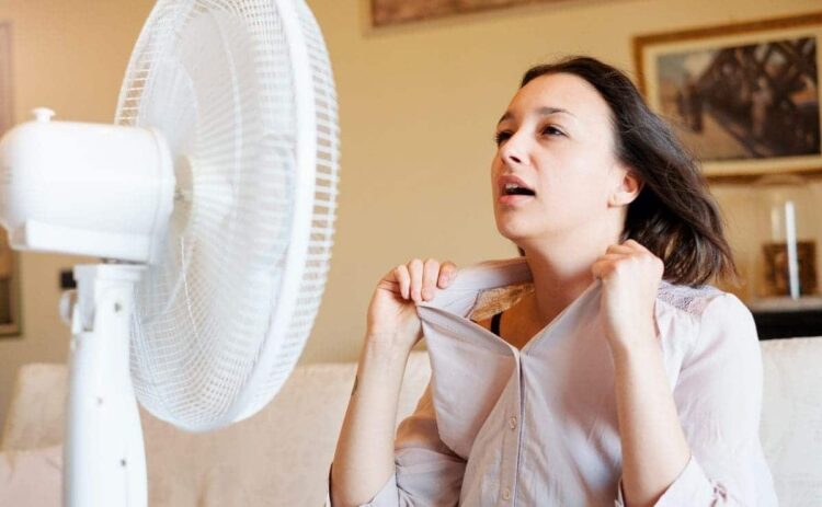 Mujer con calor por no tener aire acondicionado