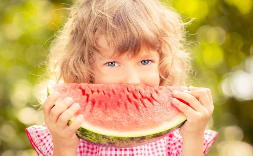 Niña comiendo sandia, una fruta rica en azucar