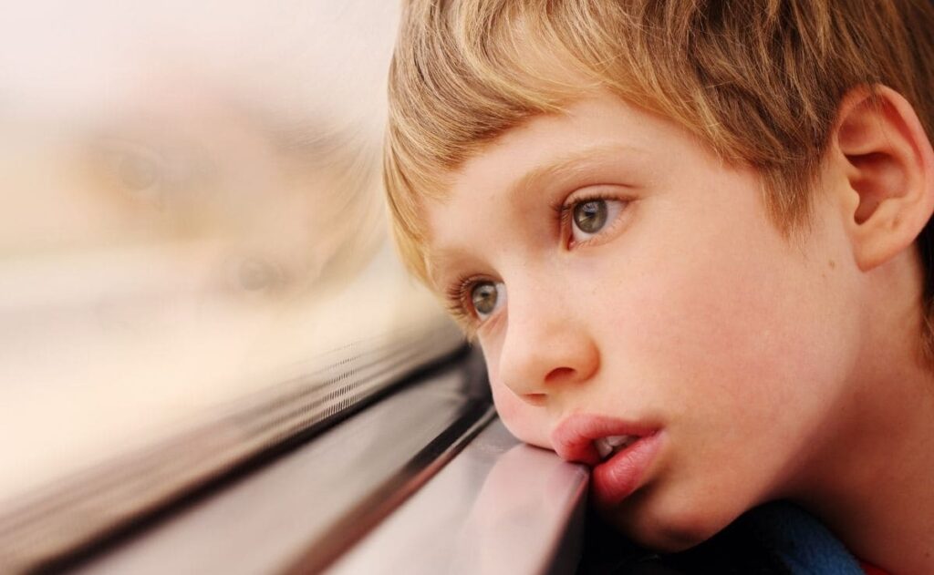 Niño con autismo mira por la ventana