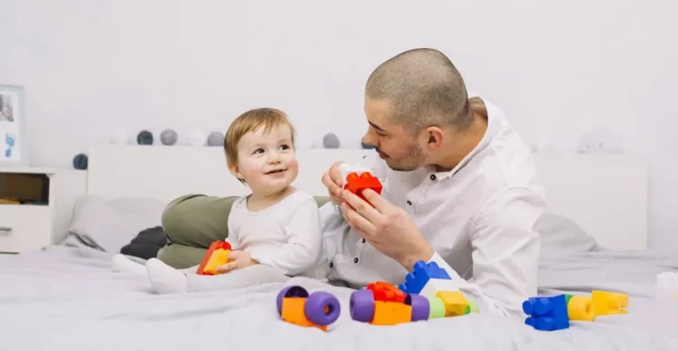 Hombre con un bebé jugando en la cama