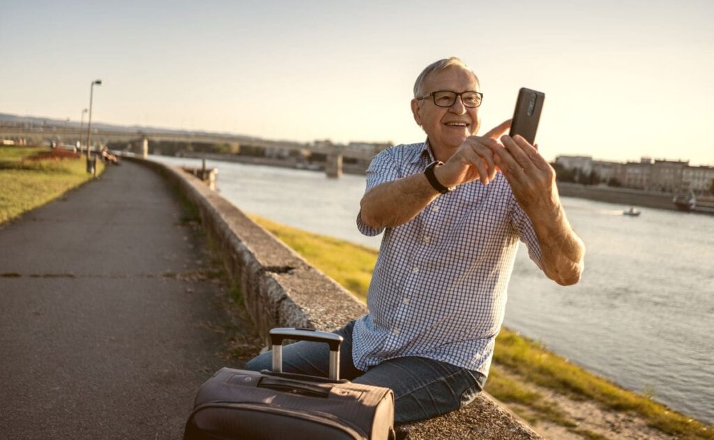 Persona mayor se hace un selfie mientras espera su viaje del IMSERSO