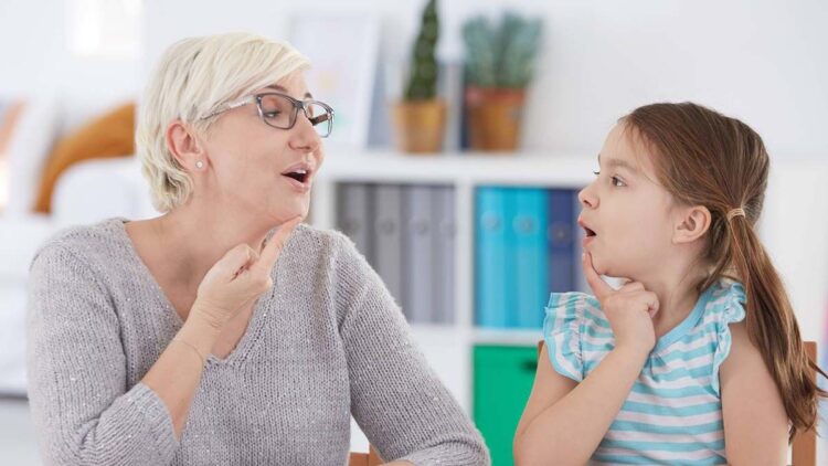 Logopeda dando clase a una niña con tartamudez